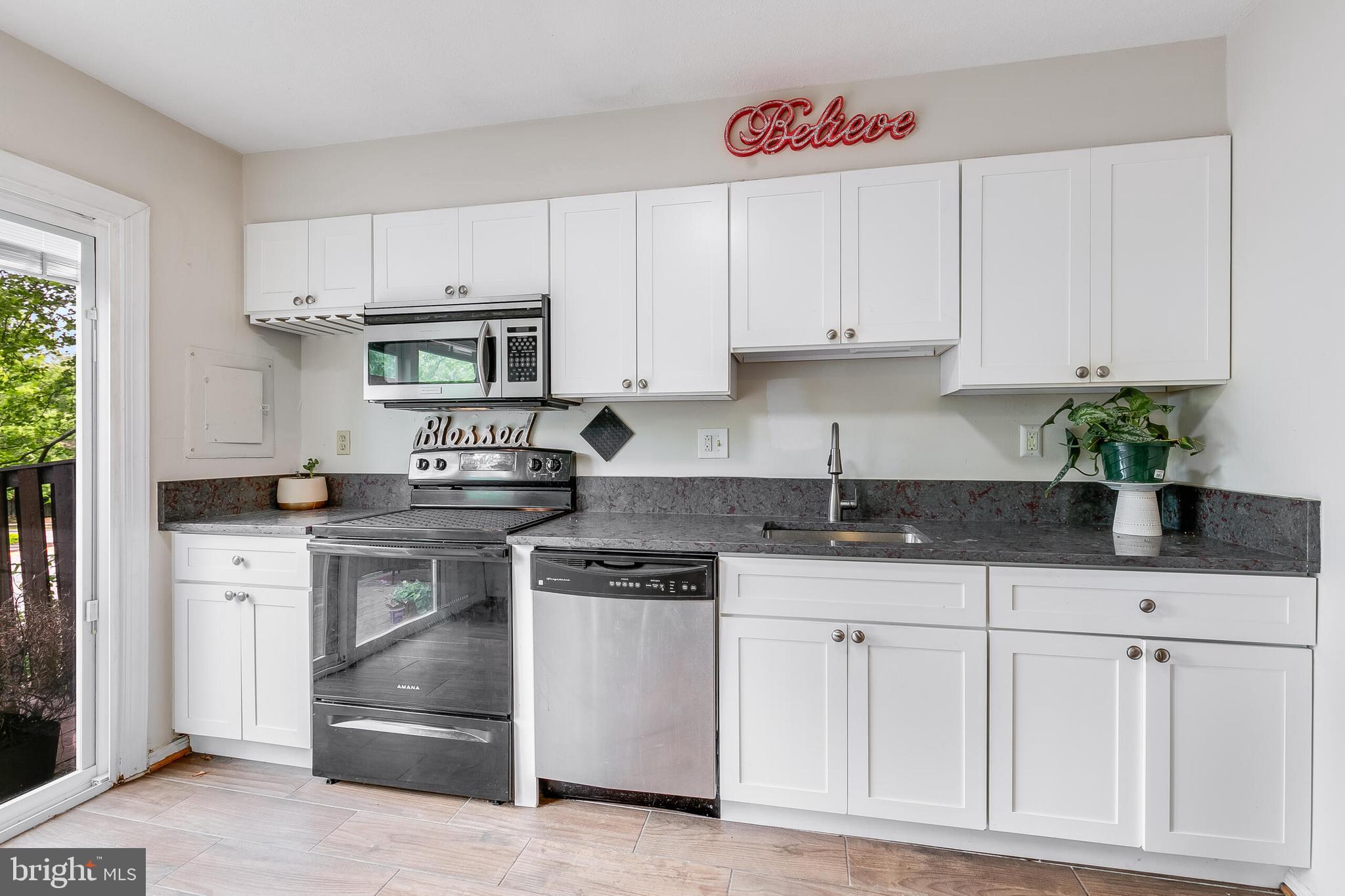 7329 Split Rail Lane Laurel, MD 20707 - Photo 9 of 32 a kitchen with granite countertop a sink stove and cabinets