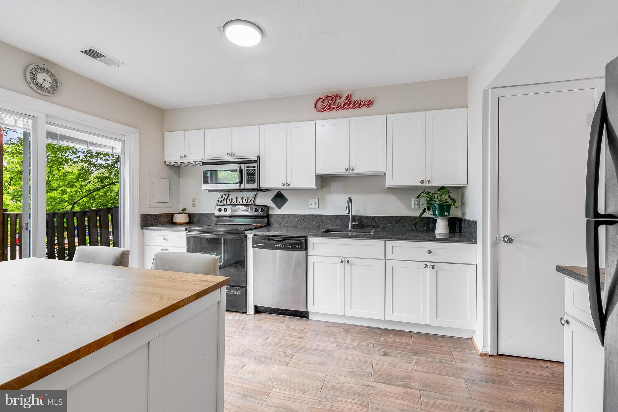 7329 Split Rail Lane Laurel, MD 20707 - Photo 10 of 32 a kitchen with granite countertop white cabinets and white appliances
