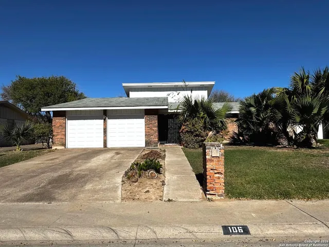 a view of a house with a yard and garage