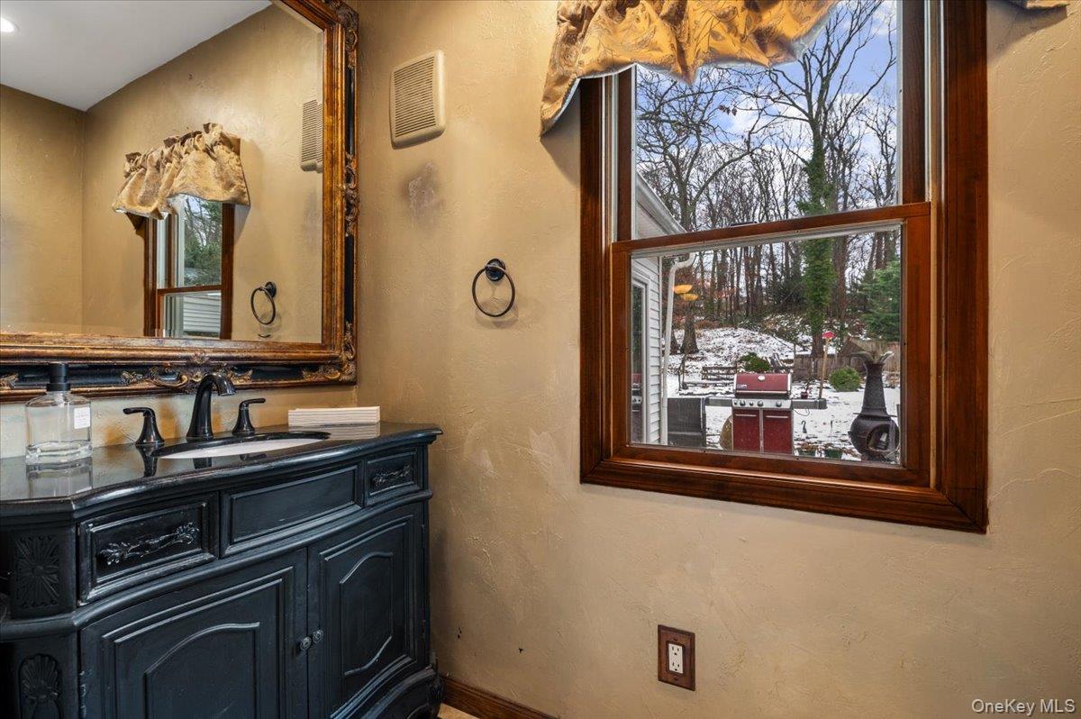 33 Fleets Cove Road Huntington, NY 11743 - Photo 18 of 44 a bathroom with a sink a mirror and a window