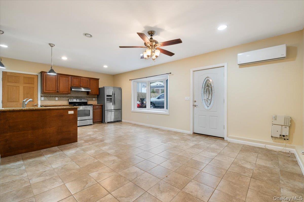 33 Fleets Cove Road Huntington, NY 11743 - Photo 26 of 44 a living room with stainless steel appliances kitchen island granite countertop a refrigerator and a stove top oven
