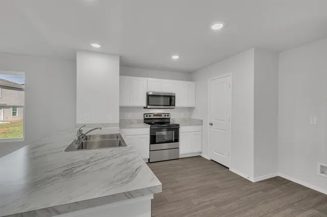 a kitchen with granite countertop a stove and a refrigerator