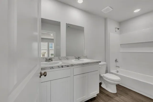 a bathroom with a granite countertop toilet a sink and a mirror