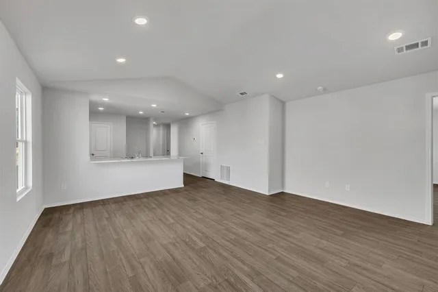 a view of an empty room with wooden floor