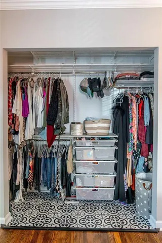 a view of walk in closet with clothes and shoes