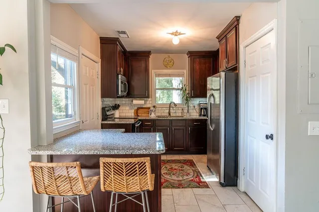 a kitchen with a granite countertop sink refrigerator and window