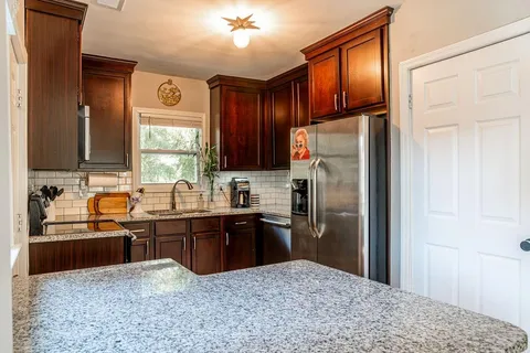 a kitchen with stainless steel appliances granite countertop a refrigerator and a sink