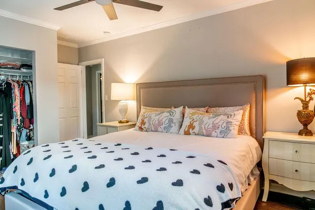 a large bed sitting in a bedroom next to a lamp and a chandelier