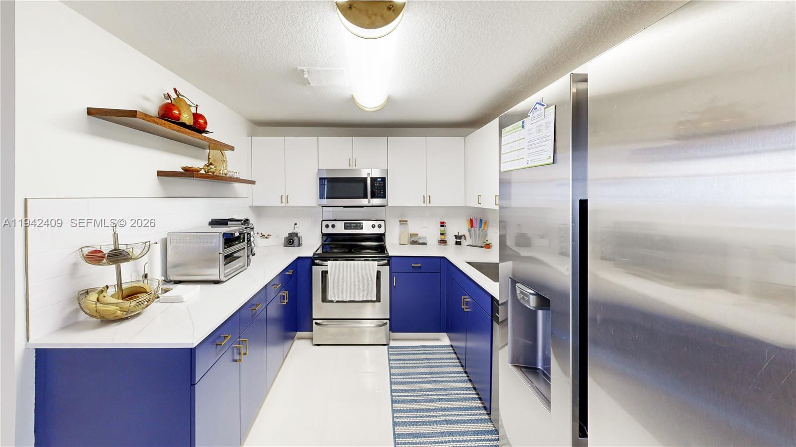 10210 Southwest 154th Place, Unit 1118 Miami, FL 33196 - Photo 12 of 59 a kitchen with kitchen island granite countertop stainless steel appliances and a sink