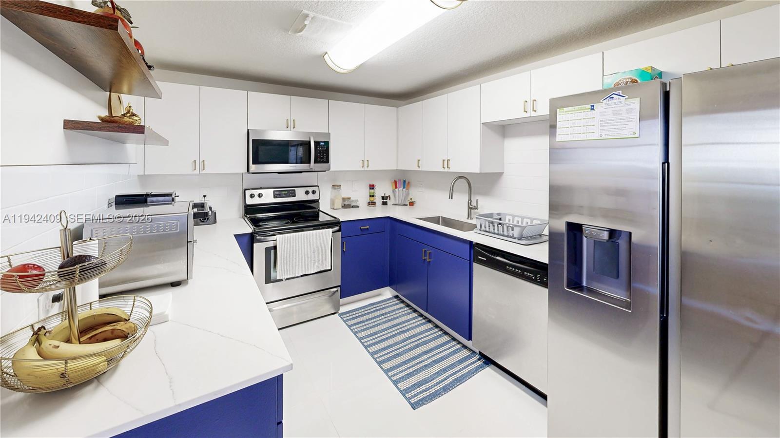 10210 Southwest 154th Place, Unit 1118 Miami, FL 33196 - Photo 13 of 59 a kitchen with stainless steel appliances granite countertop a sink stove and refrigerator