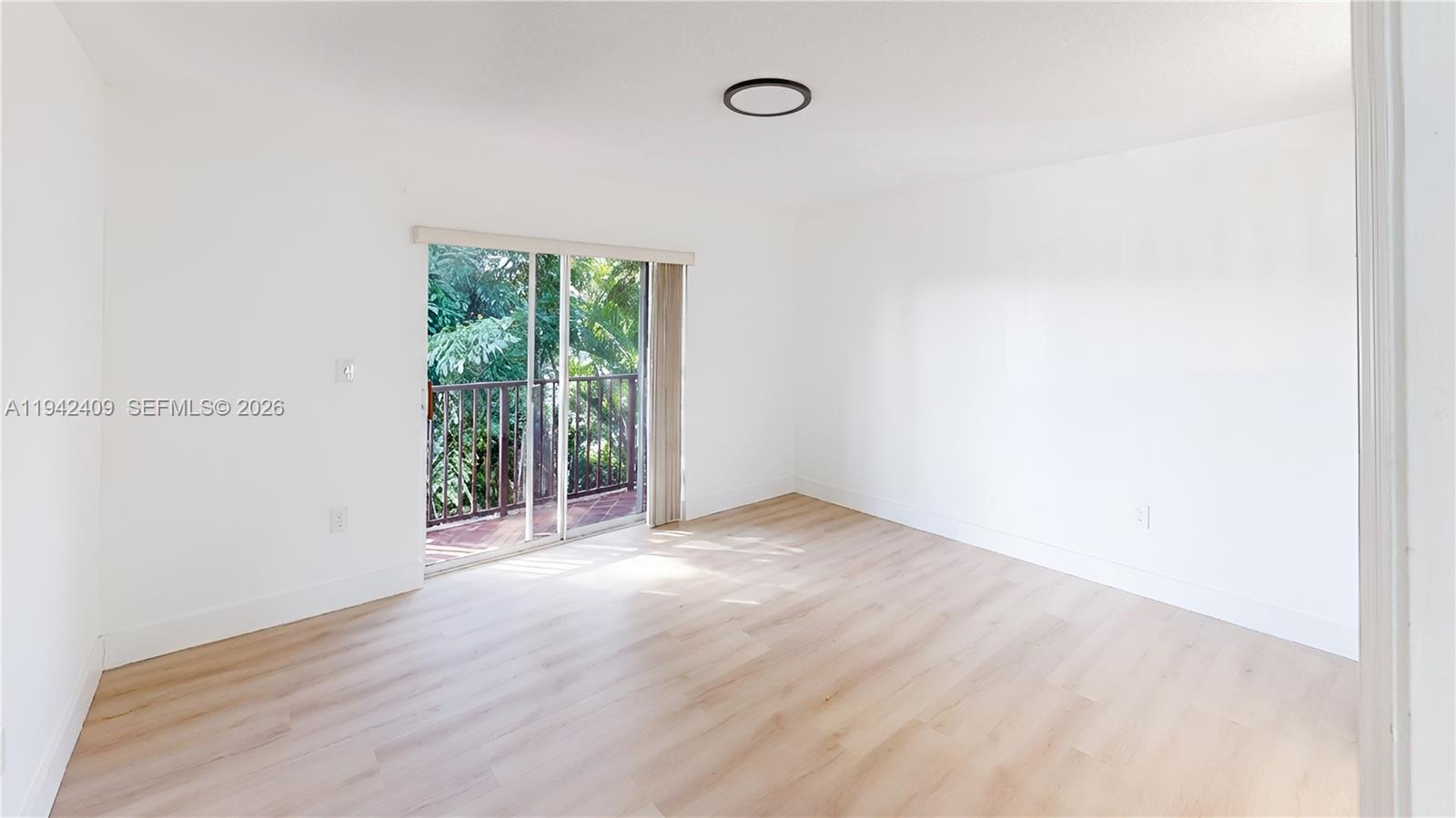 10210 Southwest 154th Place, Unit 1118 Miami, FL 33196 - Photo 21 of 59 a view of an empty room with wooden floor and a window