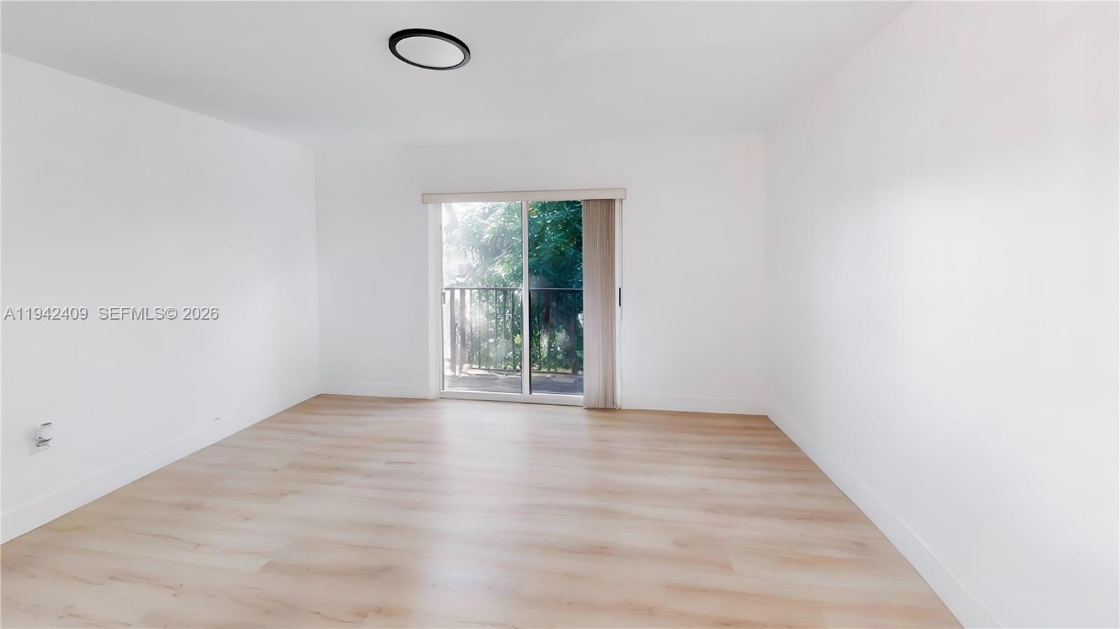 10210 Southwest 154th Place, Unit 1118 Miami, FL 33196 - Photo 24 of 59 an empty room with wooden floor and windows
