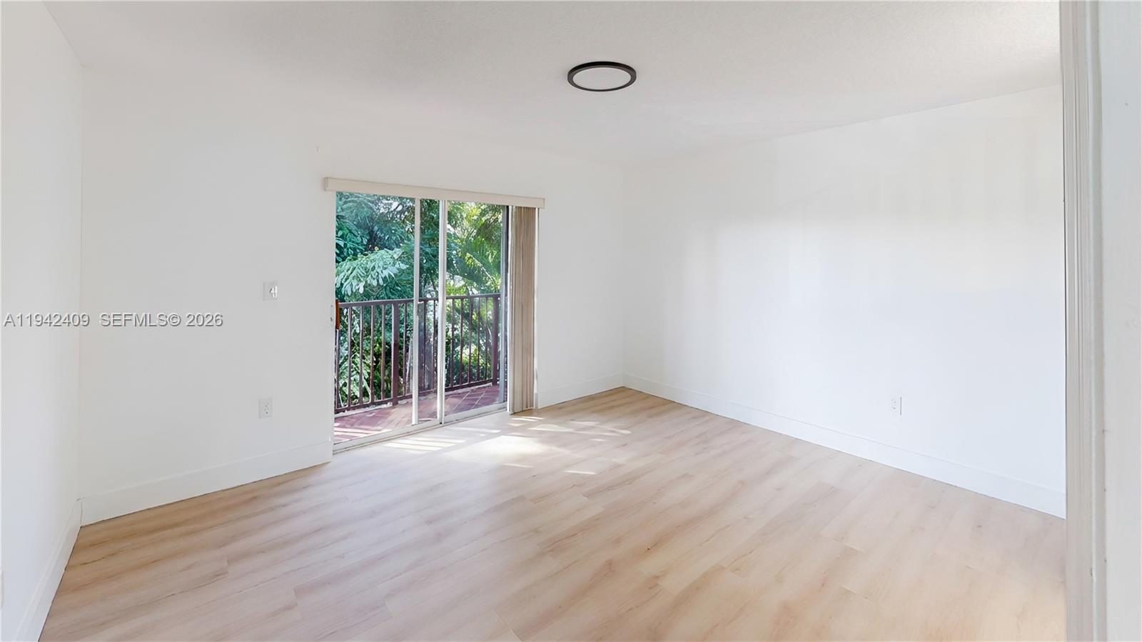 10210 Southwest 154th Place, Unit 1118 Miami, FL 33196 - Photo 27 of 71 a view of an empty room with wooden floor and a window