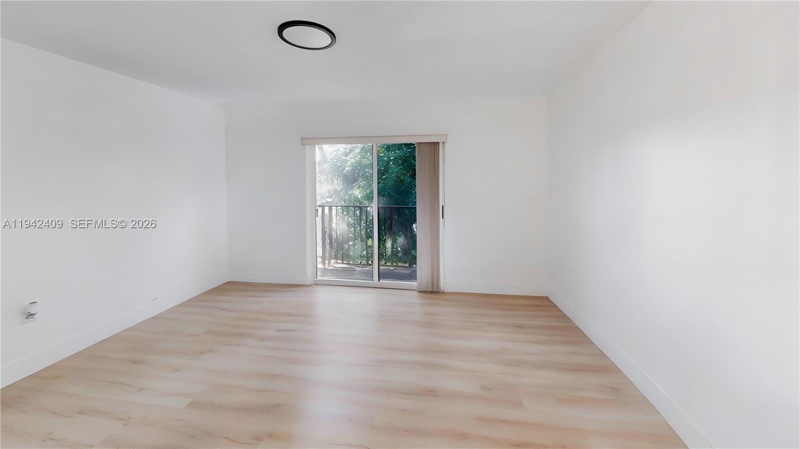 10210 Southwest 154th Place, Unit 1118 Miami, FL 33196 - Photo 30 of 71 an empty room with wooden floor and windows