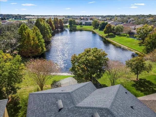 an aerial view of a house with a garden and lake view