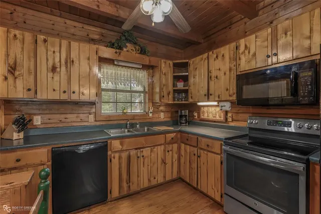 a kitchen with stainless steel appliances granite countertop a sink a stove a microwave and wooden cabinets