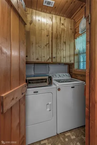 a view of washer and dryer with wooden walls