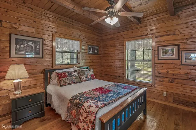 a bedroom with a bed next to a window and a flat screen tv