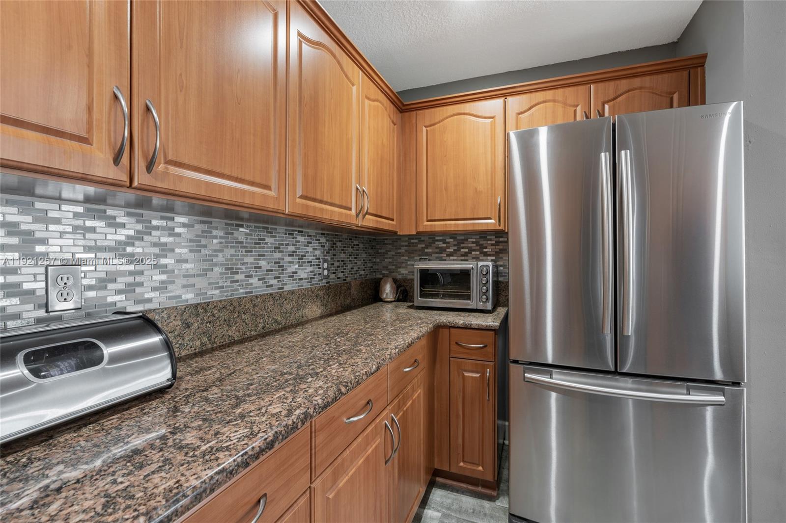 4055 Eastridge Drive Deerfield Beach, FL 33064 - Photo 18 of 56 a kitchen with stainless steel appliances granite countertop a refrigerator a sink and white cabinets