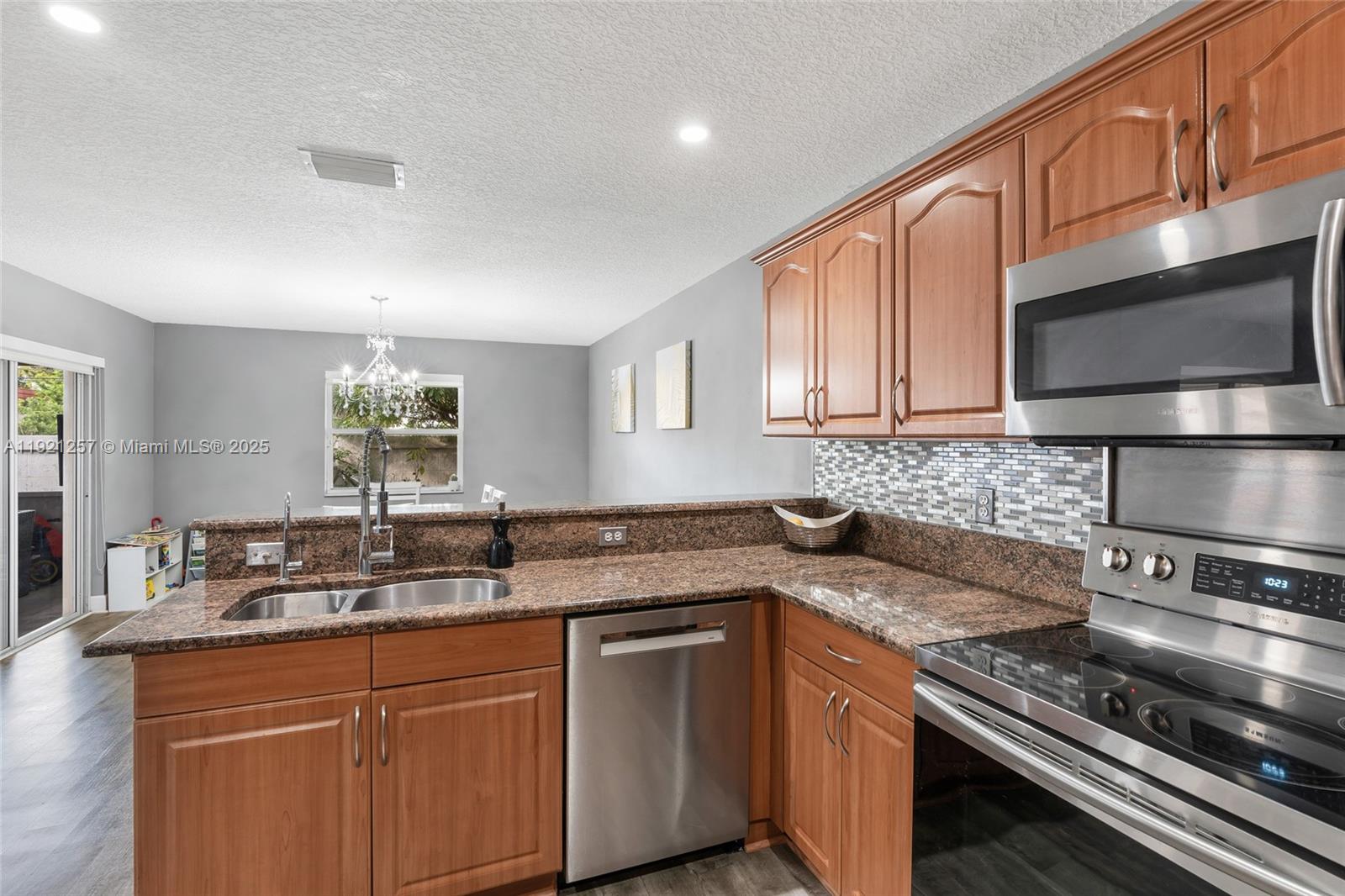 4055 Eastridge Drive Deerfield Beach, FL 33064 - Photo 19 of 56 a kitchen with stainless steel appliances granite countertop a sink stove and microwave