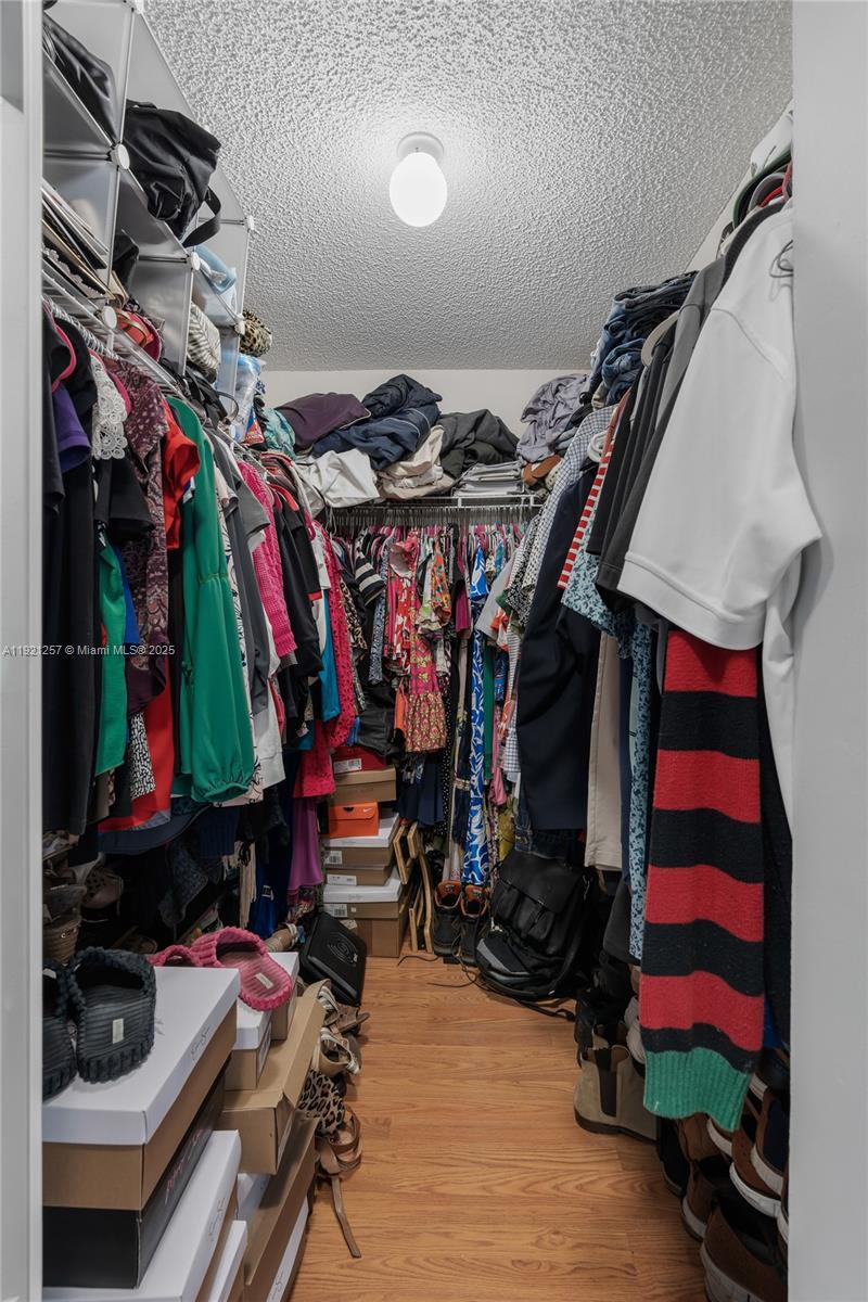 4055 Eastridge Drive Deerfield Beach, FL 33064 - Photo 37 of 56 a view of walk in closet with clothes and shoes