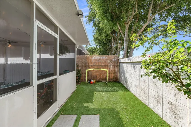 a view of a swimming pool with lawn chairs and potted plants