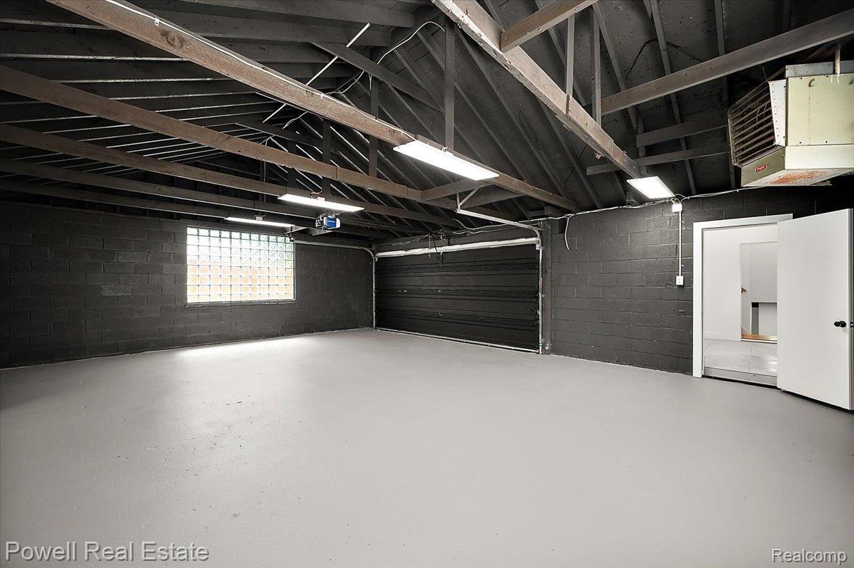 6837 Hatchery Road Waterford, MI 48327 - Photo 54 of 56 Garage with concrete block wall, a heating unit, and a garage door opener