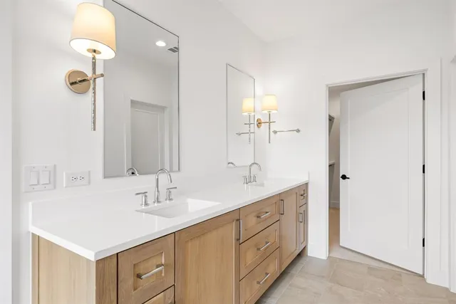 a spacious bathroom with a double vanity sink mirror and bathtub