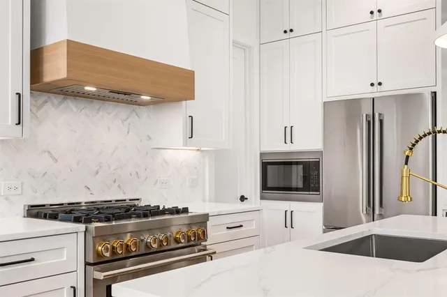 a large kitchen with stainless steel appliances kitchen island a refrigerator and a sink