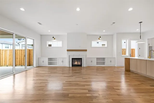 a view of empty room with wooden floor and fireplace