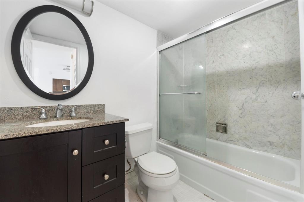 1625 Southeast 10th Avenue, Unit 508 Fort Lauderdale, FL 33316 - Photo 15 of 22 a bathroom with a granite countertop toilet a sink and a mirror