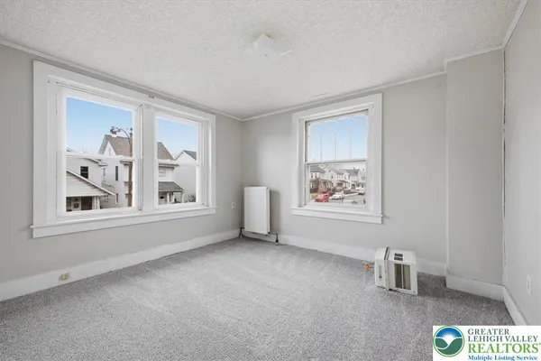 an empty room with windows and cabinet