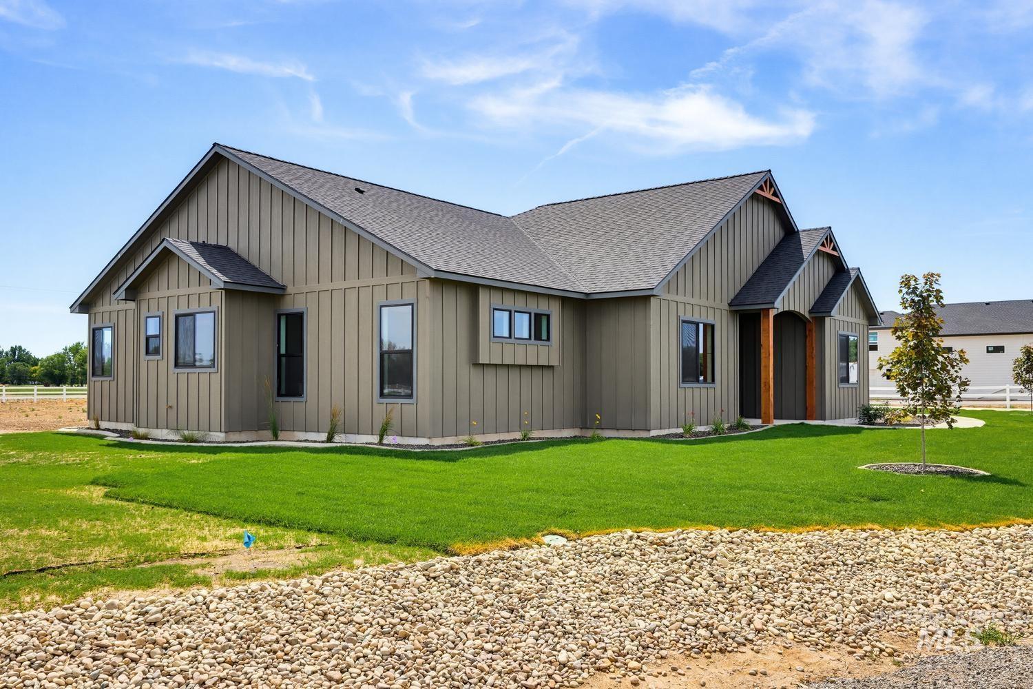 5054 Heritage Drive Marsing, ID 83639 - Photo 2 of 38 Contemporary residence featuring board and batten siding, a dark shingle roof, and a mature front lawn