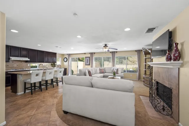 a living room with furniture kitchen view and a chandelier