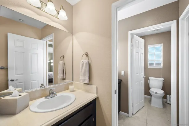 a view of bathroom with a sink mirror and toilet