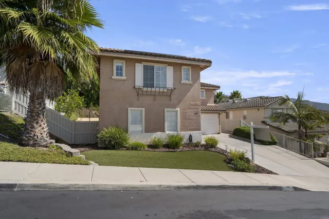 a front view of a house with garage and plants