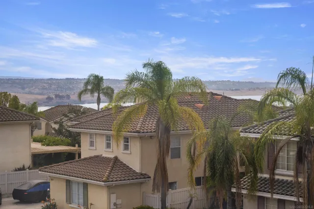 a front view of a house with a yard and mountain view in back
