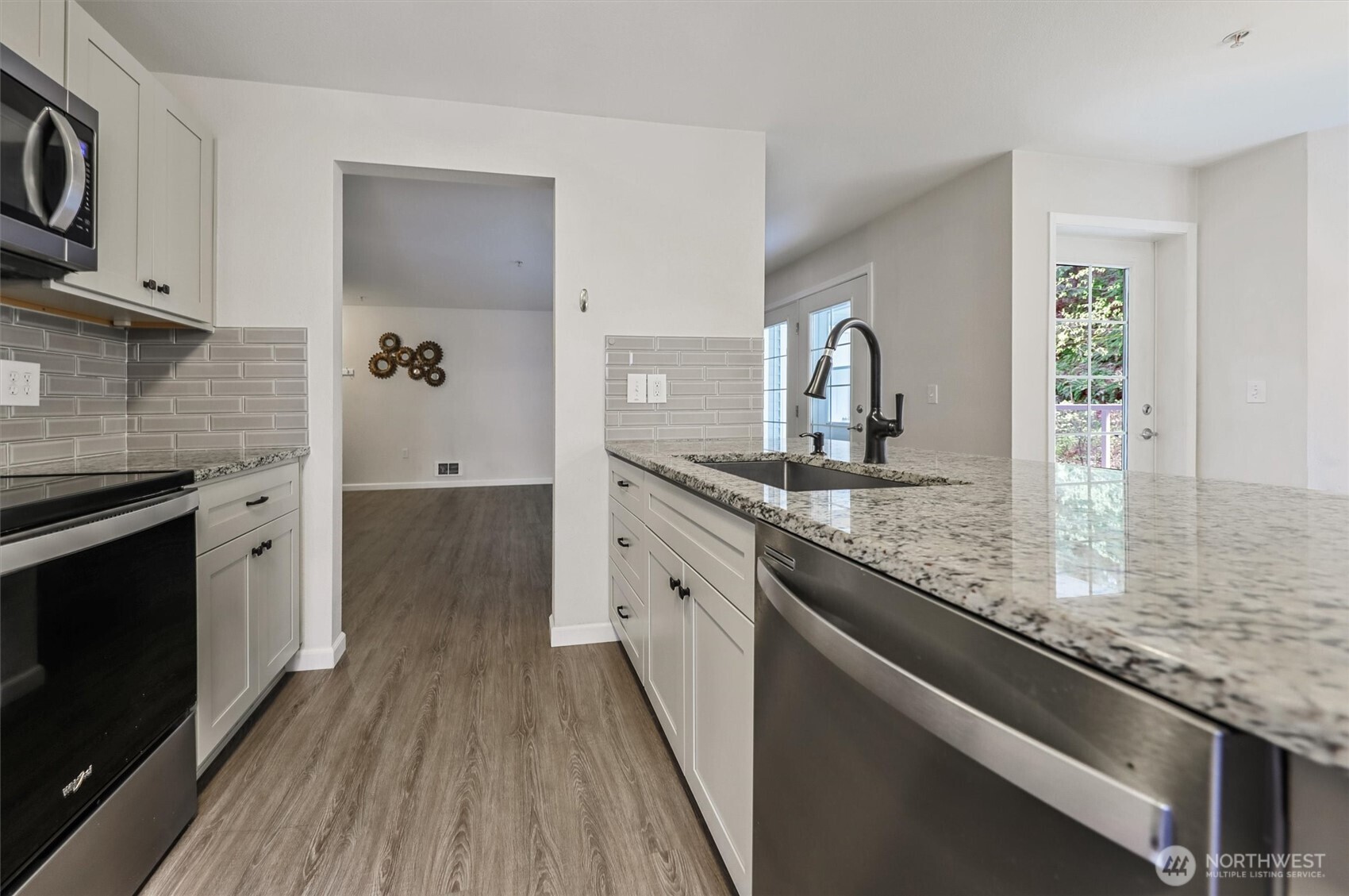 715 Harrington Place Southeast, Unit 2140 Renton, WA 98058 - Photo 16 of 36 a kitchen with granite countertop a sink stove and cabinets