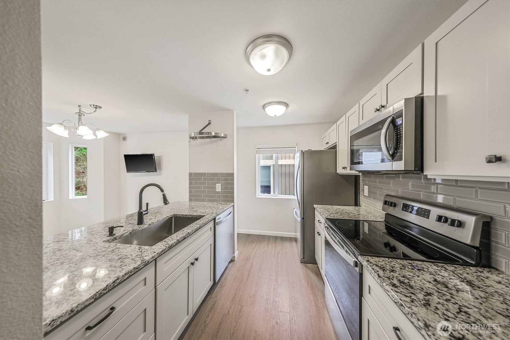 715 Harrington Place Southeast, Unit 2140 Renton, WA 98058 - Photo 18 of 36 a kitchen with stainless steel appliances granite countertop a sink and stove top oven