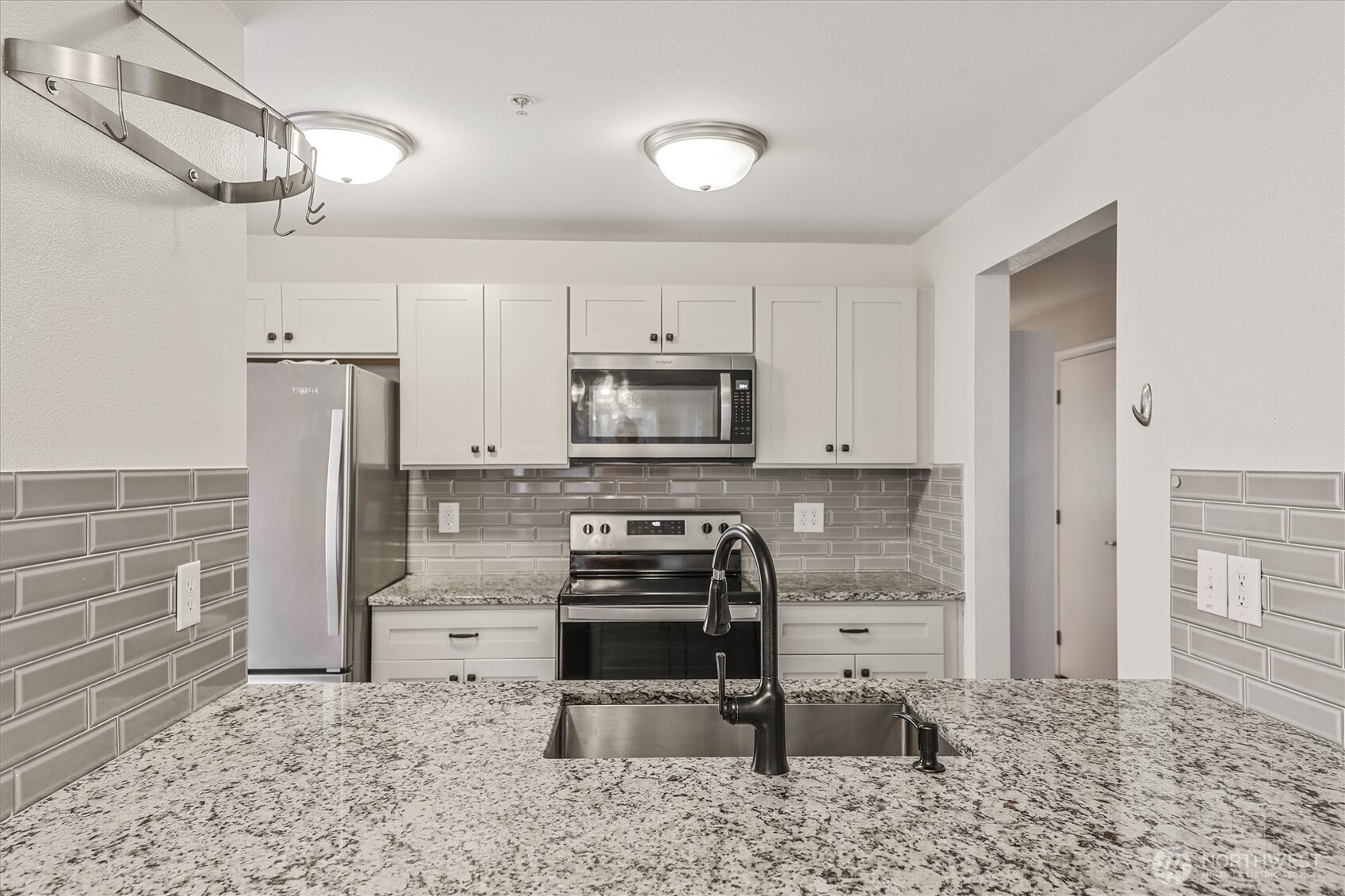 715 Harrington Place Southeast, Unit 2140 Renton, WA 98058 - Photo 19 of 36 a kitchen with granite countertop a refrigerator and a stove top oven