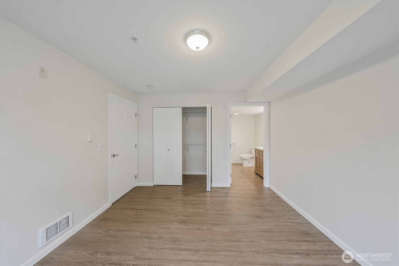 715 Harrington Place Southeast, Unit 2140 Renton, WA 98058 - Photo 25 of 36 a view of an empty room with wooden floor and a window