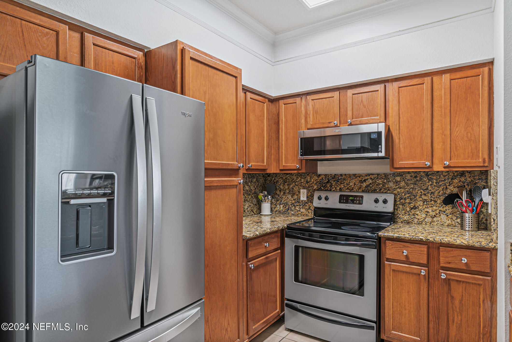8550 Touchton Road, Unit 927 Jacksonville, FL 32216 - Photo 12 of 59 a kitchen with granite countertop a refrigerator stove and microwave