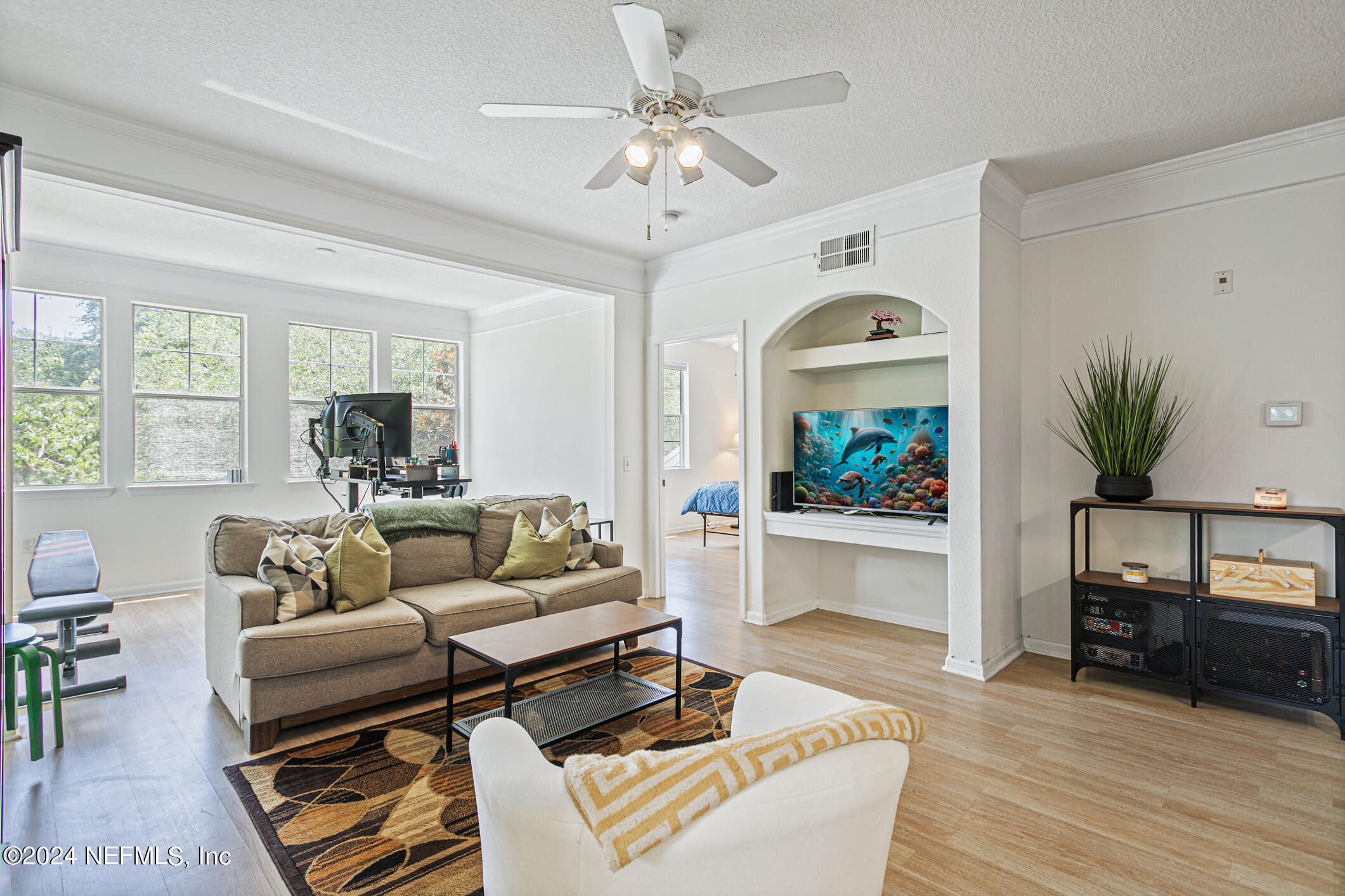 8550 Touchton Road, Unit 927 Jacksonville, FL 32216 - Photo 15 of 59 a living room with furniture a chandelier and a flat screen tv