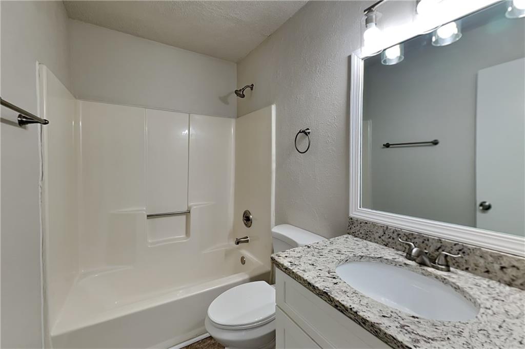 3979 Sharon Spring Powder Springs, GA 30127 - Photo 16 of 18 a bathroom with a granite countertop sink a toilet a mirror and shower