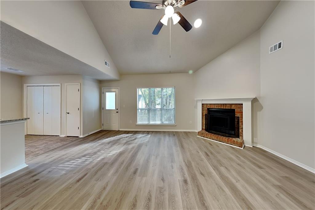 3979 Sharon Spring Powder Springs, GA 30127 - Photo 2 of 18 an empty room with wooden floor fireplace and windows