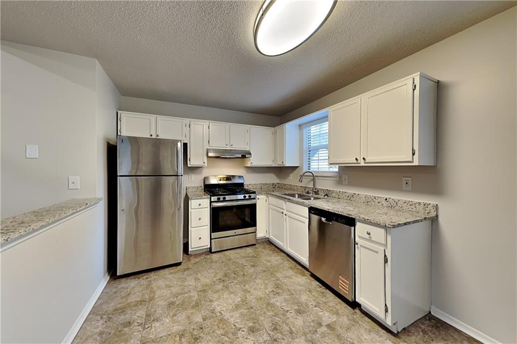 3979 Sharon Spring Powder Springs, GA 30127 - Photo 5 of 18 a kitchen with stainless steel appliances granite countertop a refrigerator sink and stove