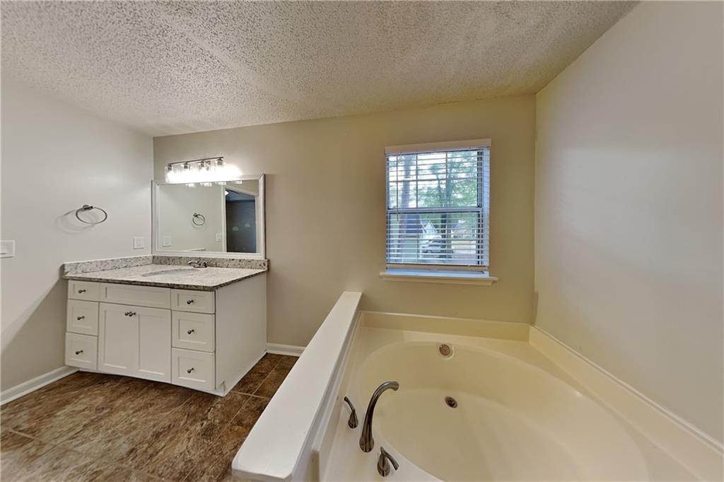 3979 Sharon Spring Powder Springs, GA 30127 - Photo 9 of 18 a bathroom with a granite countertop sink a mirror and a bathtub