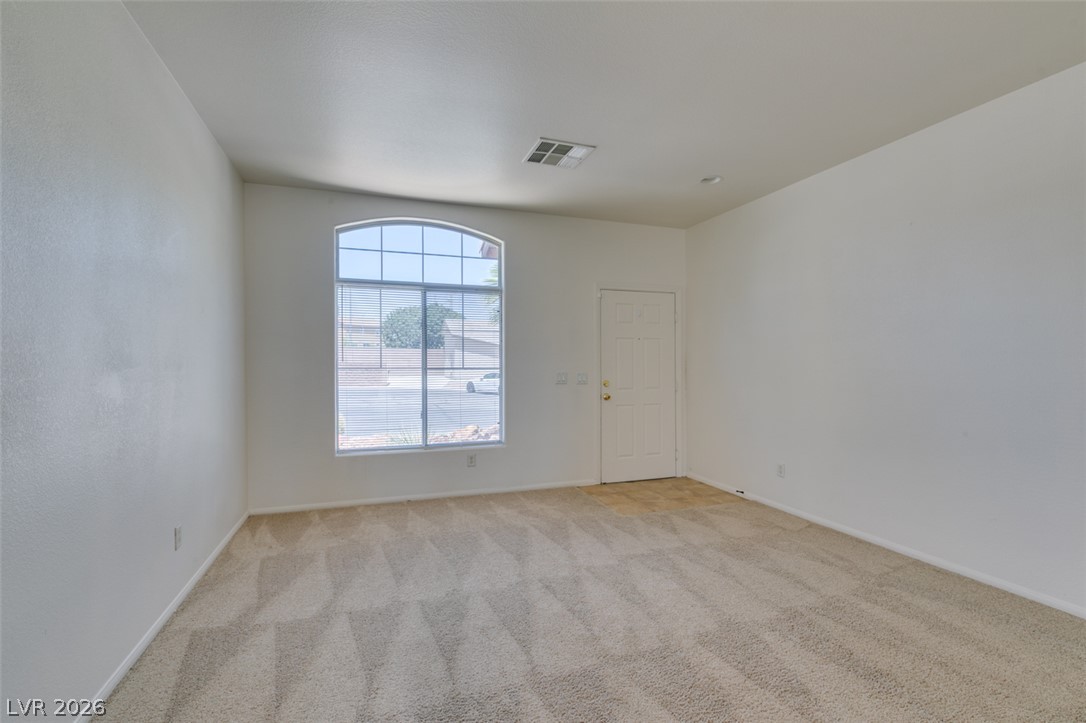 5150 Riverside Run Court North Las Vegas, NV 89081 - Photo 6 of 50 A spacious room with a welcoming front door and a gracefully arched window allowing abundant natural light.