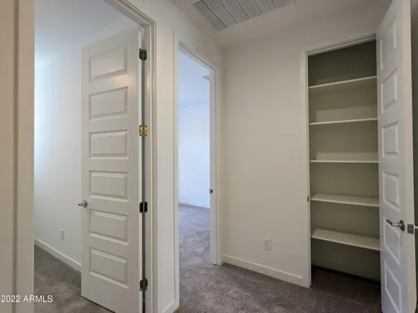 an empty room with closet and a ceiling fan