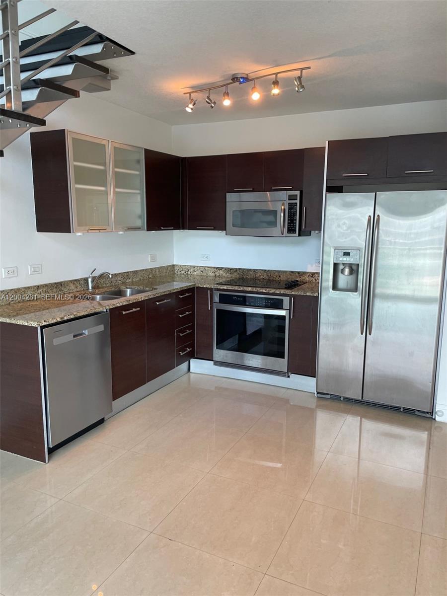 41 Southeast 5th Street, Unit 1614 Miami, FL 33131 - Photo 6 of 23 a kitchen with stainless steel appliances granite countertop a stove a sink and a refrigerator